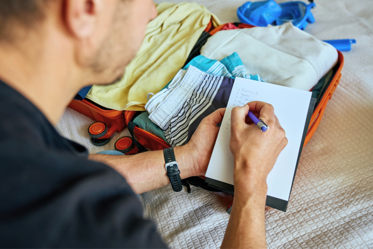 Personne écrivant près d'une valise.